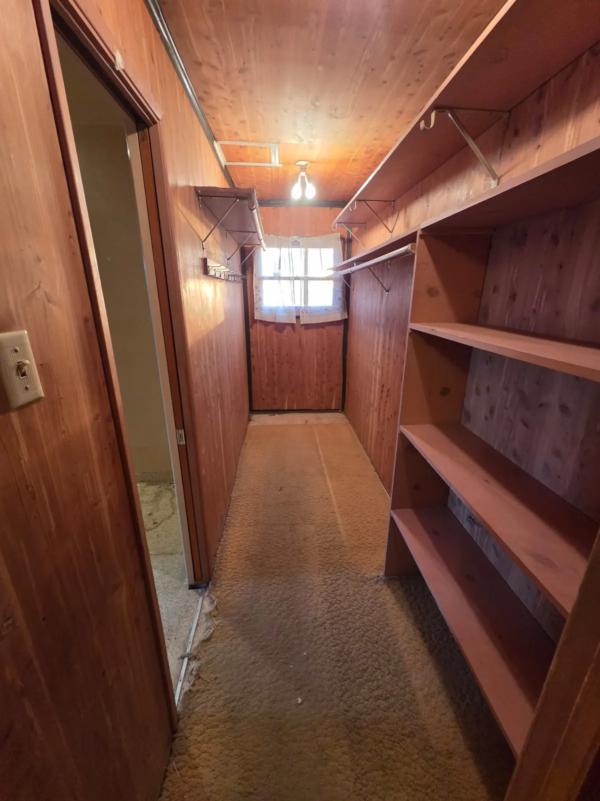 Walk-in cedar closet after: empty shelves and bare floor
