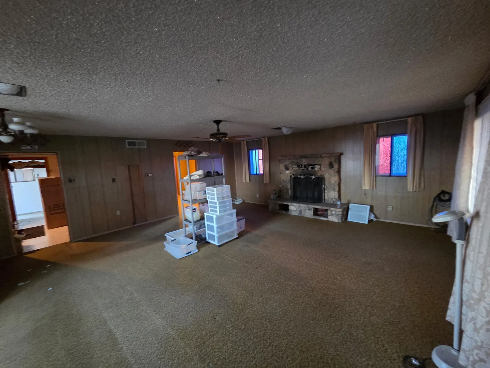 Living room after: floor cleared down to the carpet, fireplace visible