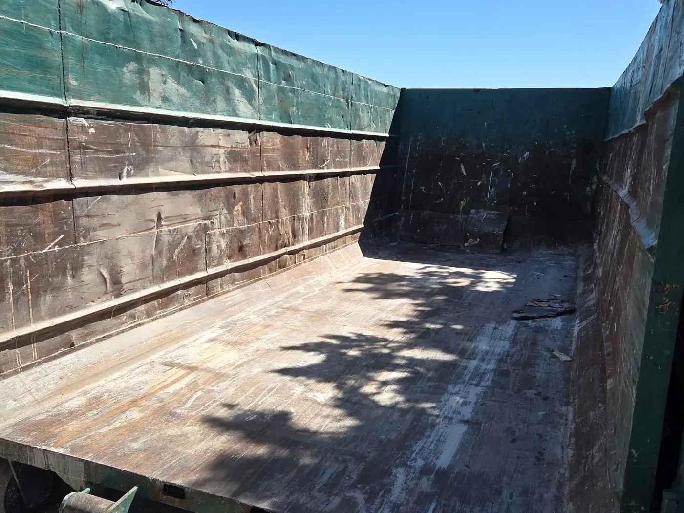 Empty Golden Strada dump trailer bed before loading