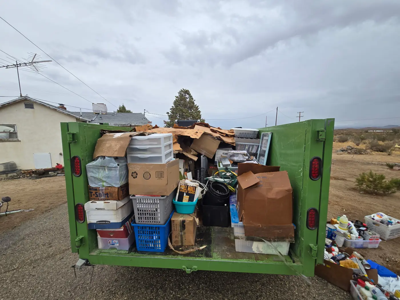 Golden Strada trailer loaded to the top with boxes, bins and household junk